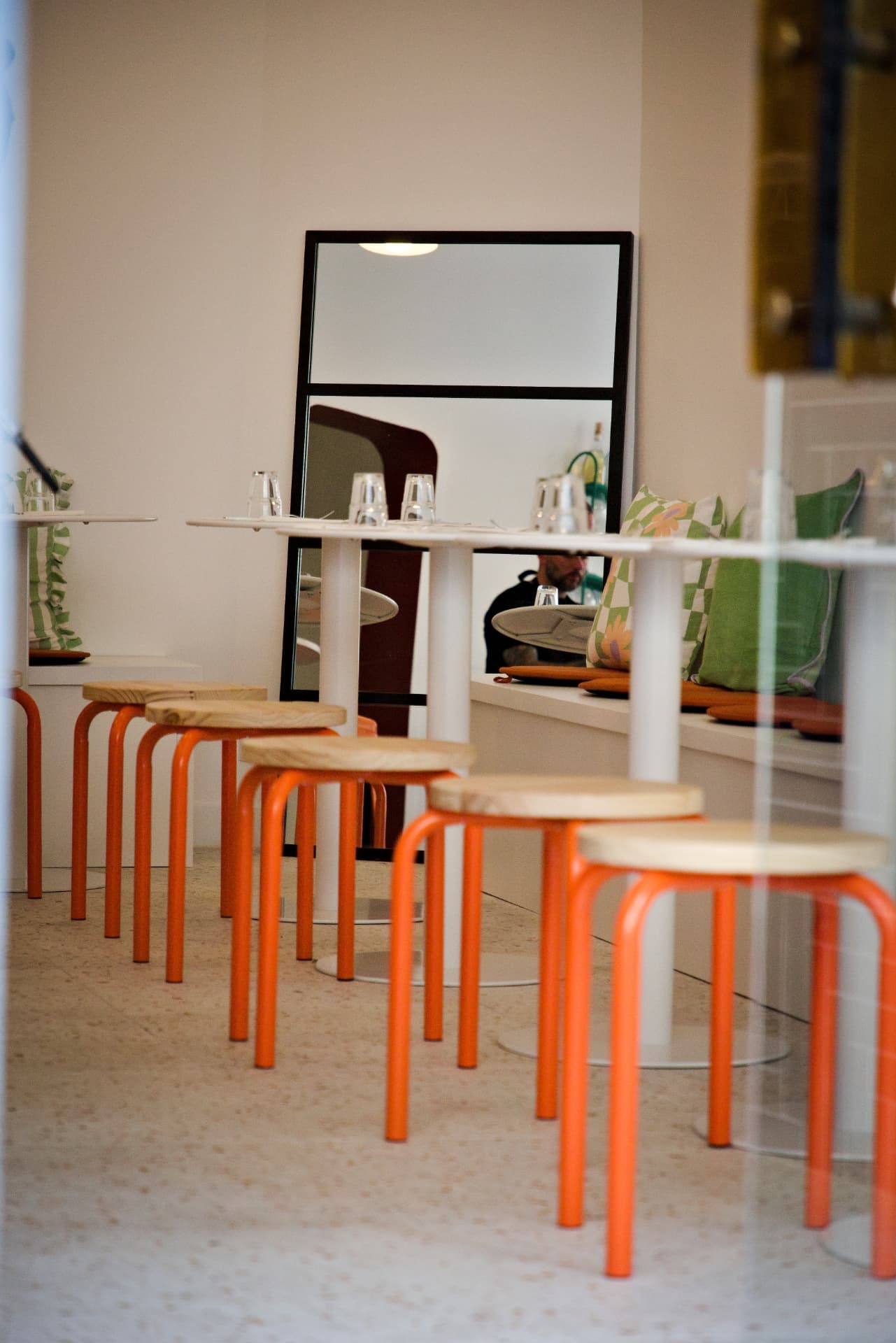 Salle du restaurant Phocéa, banquette crème et tabourets orange
